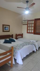 une chambre avec deux lits et un ventilateur de plafond dans l'établissement Chalés Paraíso Verde, à Itatiaia