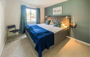 a bedroom with a bed with a blue blanket on it at 2 Bedroom Nice Home In Byxelkrok in Byxelkrok