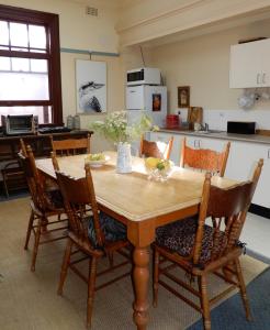 cocina con mesa y mesa de madera con sillas en Women Only Guesthouse, en Mullumbimby