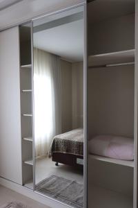 einen Spiegel in einem Schlafzimmer mit einem Bett in der Unterkunft São Bento Prime in São Bento do Sul