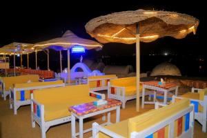 un grupo de mesas y sombrillas en una cubierta en Nubian Palace Eco Lodge, en Asuán