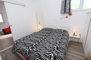 a zebra print bed in a white room with a window at Apartment Ston 10226a in Mali Ston