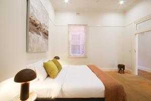 a white bedroom with a bed and a window at Waterviews - Hidden Gem in CBD - Sleeps 10 in Wagga Wagga