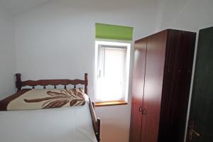 Schlafzimmer mit einem Bett, einem Fenster und einem Schrank in der Unterkunft Apartments by the sea Vinjerac, Zadar - 10413 in Vinjerac