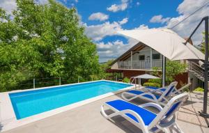 a swimming pool with two chairs and an umbrella at Family friendly house with a swimming pool Grab, Zagora - 15208 in Grab +13 photos