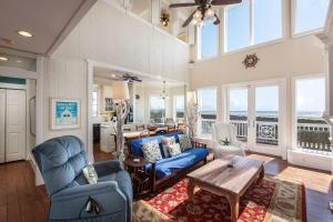 a living room with blue chairs and a table at Breakers Pointe in Galveston