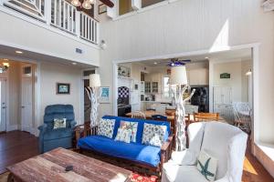 a living room with a blue couch and chairs at Breakers Pointe in Galveston +54 photos
