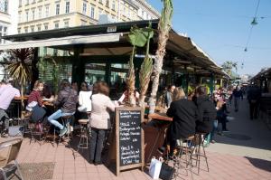 a group of people sitting at tables outside a restaurant at City Center Operastreet Apartment "Italy" in Vienna