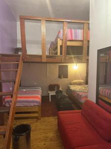 a room with two bunk beds and a couch at Bardak hostel in Cusco