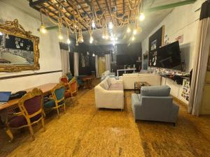 a living room with couches and chairs and a television at Bardak hostel in Cusco