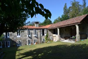 an old stone house with a red roof at Palacio de Barreiro in Crecíente