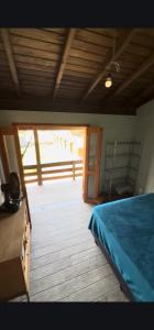Un dormitorio con una cama y suelo de madera. en Surfer paradise, en Praia do Rosa