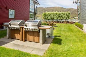 una barbacoa y una mesa de picnic en un patio en Waterfront Queenstown Studio Peaceful Stay, en Frankton