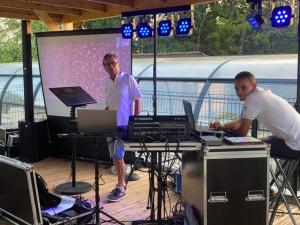 two men standing in front of a screen on a stage at Mobil home confortable avec terrasse en Charente-Maritime - API-1-52-690 in Le Fouilloux