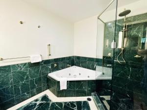 黄金海岸Boutique Ocean View Studio with King Bed & Spa的浴室配有浴缸和玻璃淋浴房