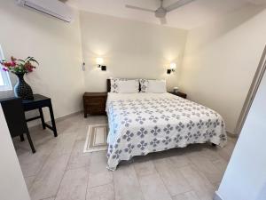 ein Schlafzimmer mit einem Bett und einem Tisch mit einer Blumenvase in der Unterkunft Karana Suite One Bedroom - K3 in Long Bay Hills + 65 Fotos