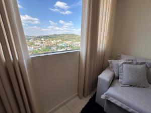 a room with a window with a chair and a view at Magnificent coverage in São Roque