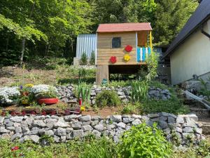 a garden with a bird house and a rock wall at Holiday house with a parking space Zlobin, Gorski kotar - 15452 in Benkovac Fužinski +6 photos