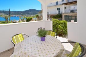 einen Tisch mit Topfpflanze auf dem Balkon in der Unterkunft Seaside holiday house Vinisce, Trogir - 16488 in Vinišće