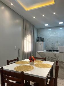 a kitchen with a table with two chairs and a white table sidx sidx at Apartamento Brisa Icaraizinho Villa brisa Icaraizinho in Amontada