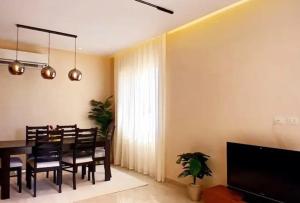 a dining room with a table and chairs and a television at elfaraag yyy in Jeddah