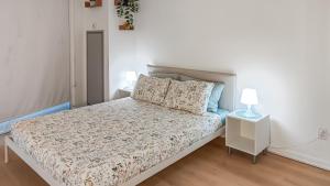 a white bedroom with a bed and two lamps at Lux suite - City View - Steps to Rogers Centre & CN Tower in Toronto