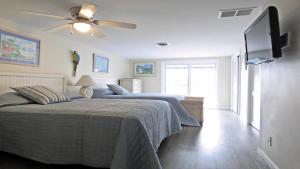 Un dormitorio con dos camas y un ventilador de techo. en Escape To Yacht - Upstairs Apartment, en Cape May
