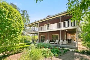 an exterior view of a house with a patio at Elderslie House - Stunning Country House in Mitchells Flat