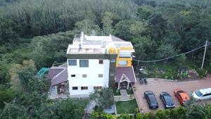 an aerial view of a house with cars parked around it at The Inchara Vista in Chikmagalūr