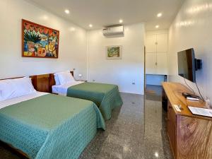 a hotel room with two beds and a flat screen tv at Strutz Art Garden Resort in Bangued +57 photos