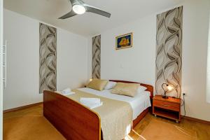a bedroom with a bed and a ceiling fan at Seaside apartments with a swimming pool Prizba, Korcula - 10056 in Brnistrova +47 photos