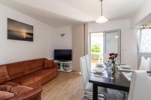 a living room with a couch and a table at Seaside apartments with a swimming pool Prizba, Korcula - 10056 in Brnistrova