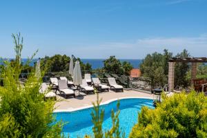 a pool with chaise lounge chairs and a swimming pool at Seaside apartments with a swimming pool Prizba, Korcula - 10056 in Brnistrova