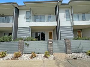 un immeuble d'appartements avec une clôture devant lui dans l'établissement Kincaid@234, à Wagga Wagga