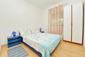 a bedroom with a blue bed and a window at Apartments by the sea Vir - 24953 in Vir