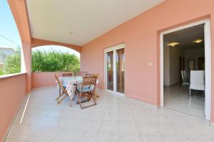 a room with a table and chairs on a patio at Apartments by the sea Vir - 24953 in Vir