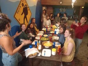 a group of people sitting around a table eating at Submarino Hostel in Florianópolis