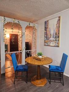 Un comedor con una mesa y dos sillas azules. en Charming Midwest 3 Bedrooms 2 Bathrooms, en Altus