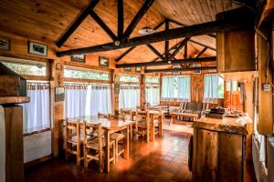 a dining room with a table and chairs in a cabin at Nahuel Mapi Lodge in Pilolil