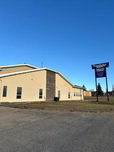 a large white building with a street sign next to it at Travelodge by Wyndham Valleyview AB in Valleyview