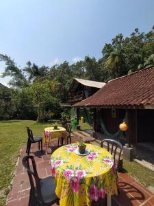 a table with a yellow table cloth on a patio at Recanto Ana Valentin in Paranaguá