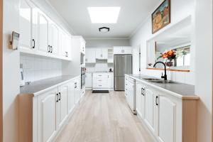 a kitchen with white cabinets and a sink at The Waratah Escape Nowra in Nowra