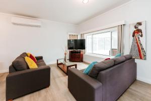a living room with two couches and a television at The Waratah Escape Nowra in Nowra