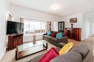 a living room with a couch and a tv at The Waratah Escape Nowra in Nowra