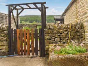 an entrance to a stone wall with a wooden gate at The Shippon in Appletreewick +18 photos