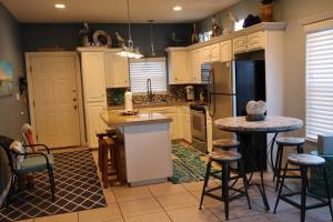 Una cocina con gabinetes blancos y una mesa y un refrigerador. en SEA DREAMS 3 condo, en South Padre Island
