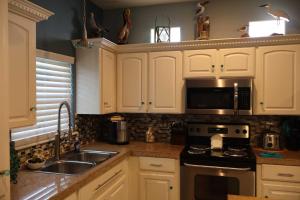 Una cocina con gabinetes blancos, un fregadero y un microondas. en SEA DREAMS 3 condo, en South Padre Island 11 fotos más