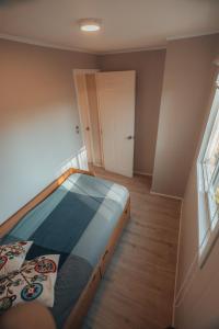 a bedroom with a bed in a room with a window at casa ikigai in Curacautín