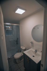 a bathroom with a toilet and a sink and a shower at casa ikigai in Curacautín