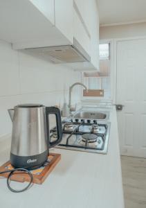 a tea kettle sitting on a stove in a kitchen at casa ikigai in Curacautín +1 photo